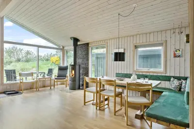 a dining room with a table and chairs and a fireplace at BL1522-Saltum-Kordalslien-25 in Saltum