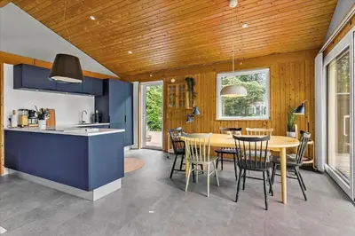 a kitchen and dining room with a table and chairs at BL1728-Blokhus-Kaeruldvej-7 in Blokhus