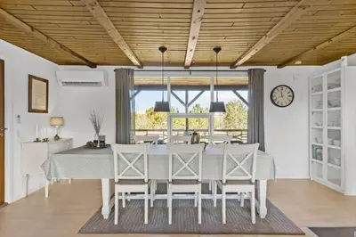 a dining room with a table and chairs and a clock at BL1136-Blokhus-Graevlingevej-6 in Blokhus