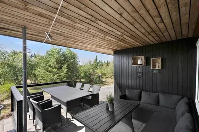 a patio with a couch and a table and chairs at BL1136-Blokhus-Graevlingevej-6 in Blokhus