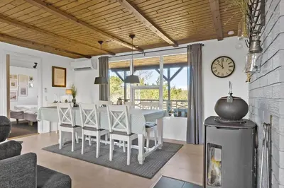 a dining room with a table and chairs and a clock at BL1136-Blokhus-Graevlingevej-6 in Blokhus