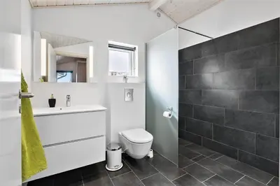 a bathroom with a toilet and a sink and a shower at BL239-Blokhus-Klitgaardsvej-21 in Blokhus