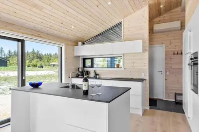 a kitchen with white cabinets and a counter with wine glasses at BL1464-Saltum-Nordvestvej-34 in Saltum