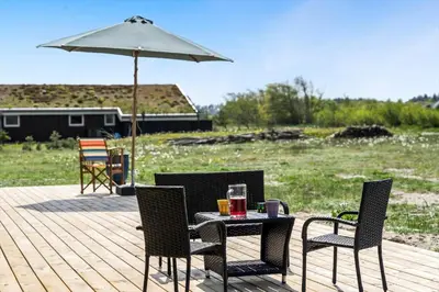 a table and chairs with an umbrella on a deck at BL1464-Saltum-Nordvestvej-34 in Saltum