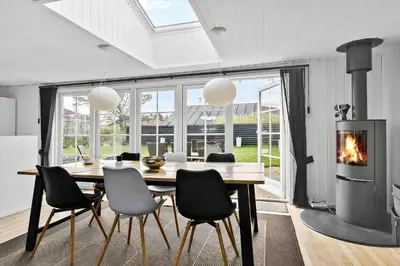 a dining room with a table and a fireplace at BL856-Blokhus-Soren-Tjenersvej-2 in Blokhus