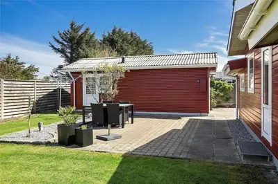 a patio with a table in front of a building at BL141-Blokhus-Vigen-12 in Blokhus