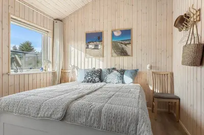 a bedroom with a bed and a window at BL1317-Blokhus-Frederiksensvej-5 in Blokhus