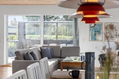 a living room with a couch and a large window at BL1317-Blokhus-Frederiksensvej-5 in Blokhus