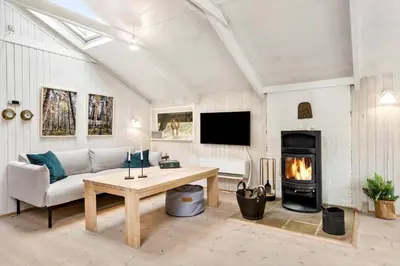 a living room with a couch and a fireplace at BL353-Blokhus-Kragebak-1 in Blokhus