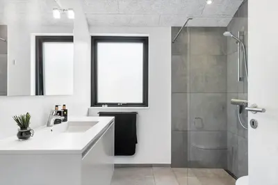 a white bathroom with a sink and a shower at BL1465-Blokhus-Bag-Hojen-8-c in Blokhus