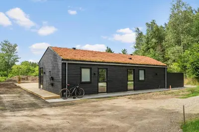 a black house with a bike parked in front of it at BL1465-Blokhus-Bag-Hojen-8-c in Blokhus