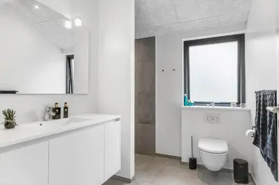 a white bathroom with a toilet and a sink at BL1465-Blokhus-Bag-Hojen-8-c in Blokhus