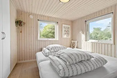 a bedroom with two pillows on a bed with two windows at BL1785-Blokhus-Jaegerensvej-18 in Blokhus
