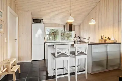 a kitchen with a white refrigerator and white stools at BL1785-Blokhus-Jaegerensvej-18 in Blokhus