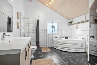 a bathroom with a tub and a toilet and a sink at BL1785-Blokhus-Jaegerensvej-18 in Blokhus