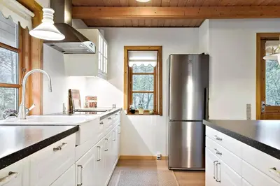 a kitchen with a stainless steel refrigerator and white cabinets at BL1553-Pandrup-Lunekrogen-9 in Pandrup