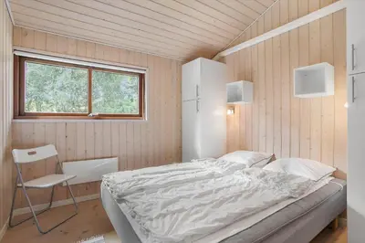 a bedroom with a bed and a chair in it at BL455-Pandrup-Rodhus-Skolevej-52 in Pandrup