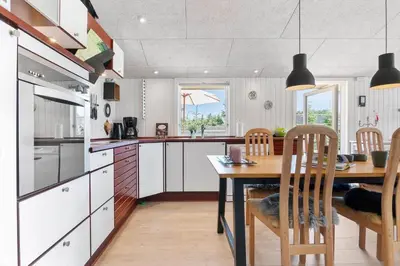 a kitchen with a wooden table and a dining room at BL1370-Saltum-Fladen-Grund-14 in Saltum