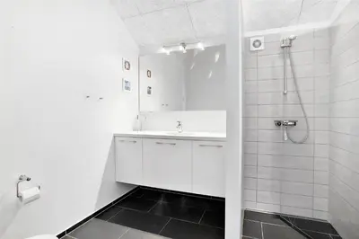 a white bathroom with a sink and a shower at BL400-Blokhus-Sdr-Strandvej-9-B in Blokhus