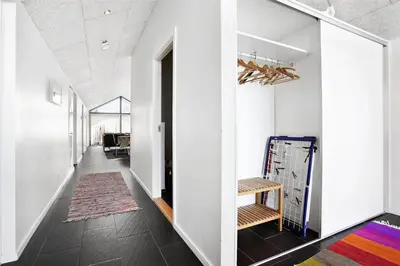 a hallway with white walls and a hallway with a rug at BL400-Blokhus-Sdr-Strandvej-9-B in Blokhus