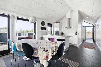 a kitchen and dining room with a table and chairs at BL400-Blokhus-Sdr-Strandvej-9-B in Blokhus