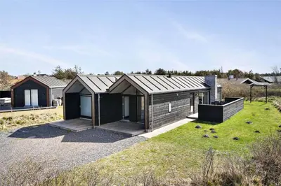 a small house with a roof on a grass field at BL400-Blokhus-Sdr-Strandvej-9-B in Blokhus