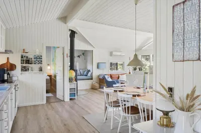 a kitchen and living room with a table and chairs at BL1383-Saltum-Foraarsvangen-18 in Saltum