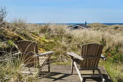 two wooden chairs sitting on a boardwalk near the beach at BL1383-Saltum-Foraarsvangen-18 in Saltum