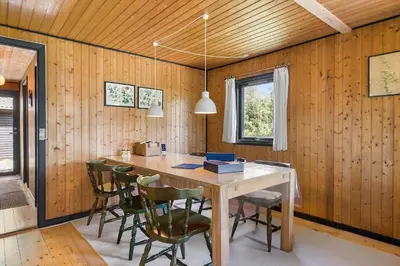 a wooden dining room with a table and chairs at BL1208-Saltum-Tippen-10 in Saltum