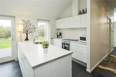 a kitchen with white cabinets and a white counter top at BL655-Blokhus-Sdr-Strandvej-11 in Blokhus