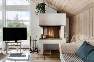 a living room with a fireplace and a television at BL1329-Blokhus-Pirupshvarrevej-67 in Blokhus
