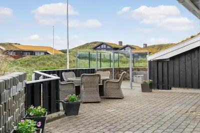 a patio with wicker chairs and tables and a fence at BL161-Saltum-Taarnfalkevej-16 in Saltum