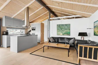 a living room with a black leather couch and a table at BL161-Saltum-Taarnfalkevej-16 in Saltum