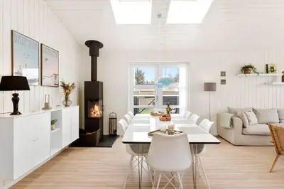 a white living room with a table and a fireplace at BL1403-Blokhus-Sorensensvej-7 in Blokhus