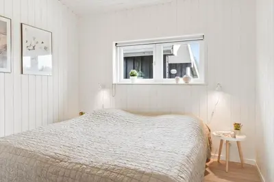 a white bedroom with a bed and a window at BL1403-Blokhus-Sorensensvej-7 in Blokhus