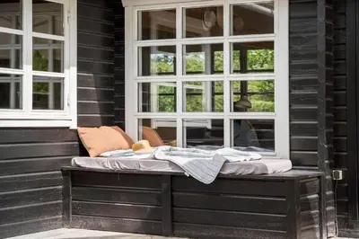 a bench on the side of a house with windows at BL1610-Blokhus-Soren-Petersvej-20 in Blokhus