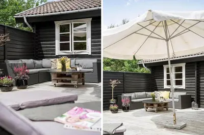 a patio with a couch and an umbrella and a table at BL1610-Blokhus-Soren-Petersvej-20 in Blokhus