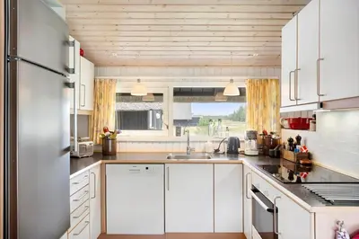 a kitchen with white cabinets and a stainless steel refrigerator at BL1394-Pandrup-Tunen-2 in Pandrup