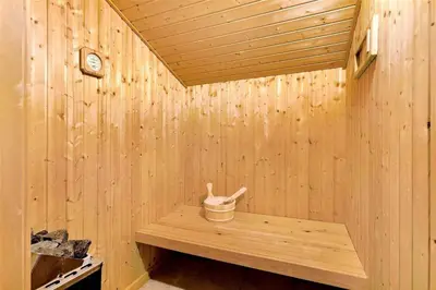 a wooden sauna with a bucket and a clock at BL1259-Blokhus-Bag-Hojen-83 in Blokhus