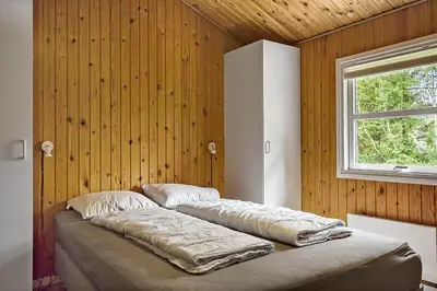 a large bed in a room with a window at BL433-Blokhus-Raappenmark-8 in Blokhus