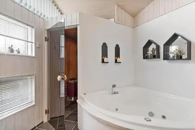 a white bathroom with a tub and a window at BL168-Saltum-Taarnfalkevej-11 in Saltum