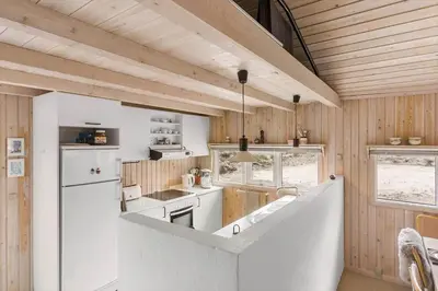 a kitchen with white appliances and wooden walls at BL1202-Saltum-Revlingevej-6 in Saltum