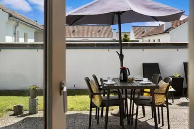 a table with an umbrella on a patio at BL1397-Pandrup-Rodhus-Klitvej-363 in Pandrup