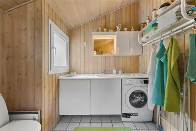a bathroom with a washing machine and a sink at BL1624-Blokhus-Jaegerbakken-1 in Blokhus