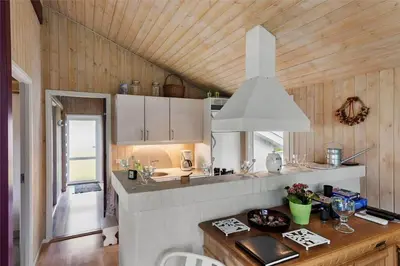 a kitchen with a wooden ceiling and a counter top at BL1624-Blokhus-Jaegerbakken-1 in Blokhus