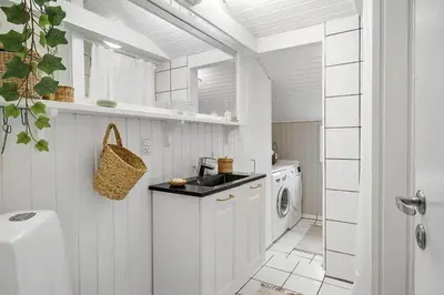 a white kitchen with a sink and a washing machine at BL1271-Blokhus-Axel-P-Jensenvej-3 in Blokhus