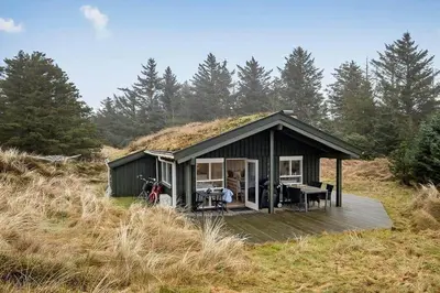 a small cabin with a grassy hill behind it at BL1271-Blokhus-Axel-P-Jensenvej-3 in Blokhus