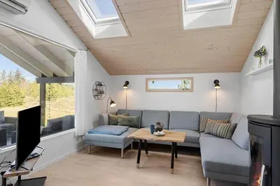a living room with a couch and a tv at BL1272-Pandrup-Kirkekrogen-7 in Pandrup