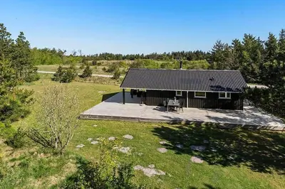 a house with a picnic table in front of it at BL1272-Pandrup-Kirkekrogen-7 in Pandrup