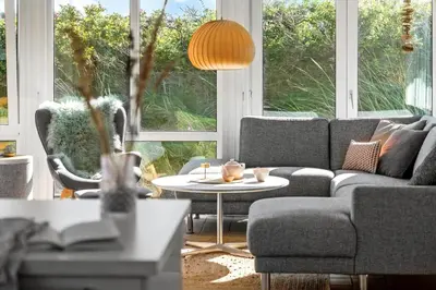 a living room with a couch and a table at BL123-Blokhus-Nonnestien-8 in Blokhus